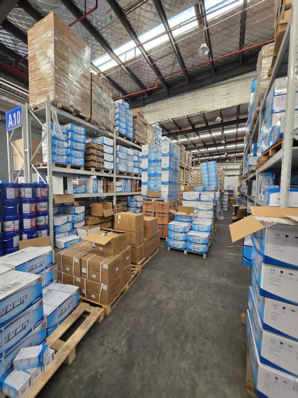 Cajas de repuestos apiladas en el pasillo del almacén